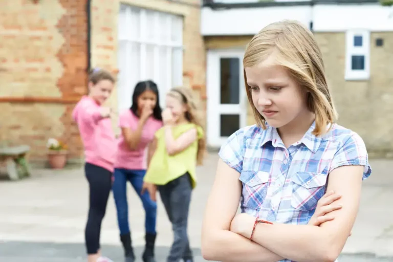 child showing signs of low confidence while other kids laugh in background